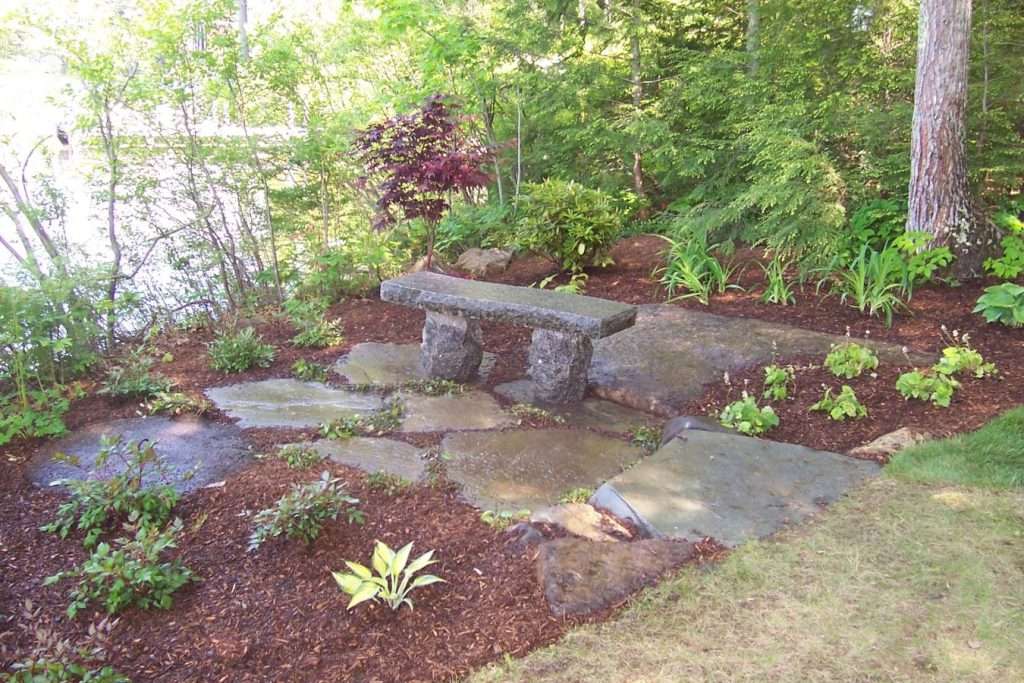 Completed backyard sitting area with custom patio, fire pit, and professional landscape design by Landscapes by Tom in New Hampshire