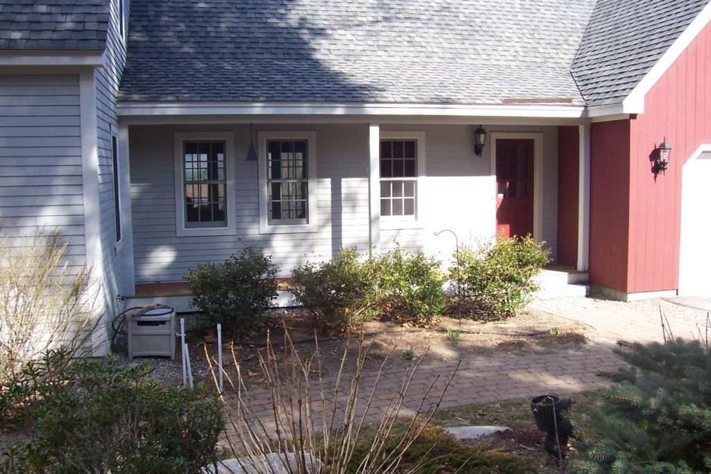 Before photo of a residential front entry planting bed prior to landscape renovation by Landscapes by Tom in New Hampshire