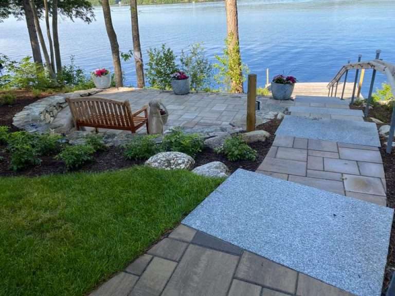 Luxury summer lake house landscaping featuring waterfront patios, natural stone walkways, granite steps, shoreline plantings, and custom outdoor living spaces designed for New Hampshire lakeside homes