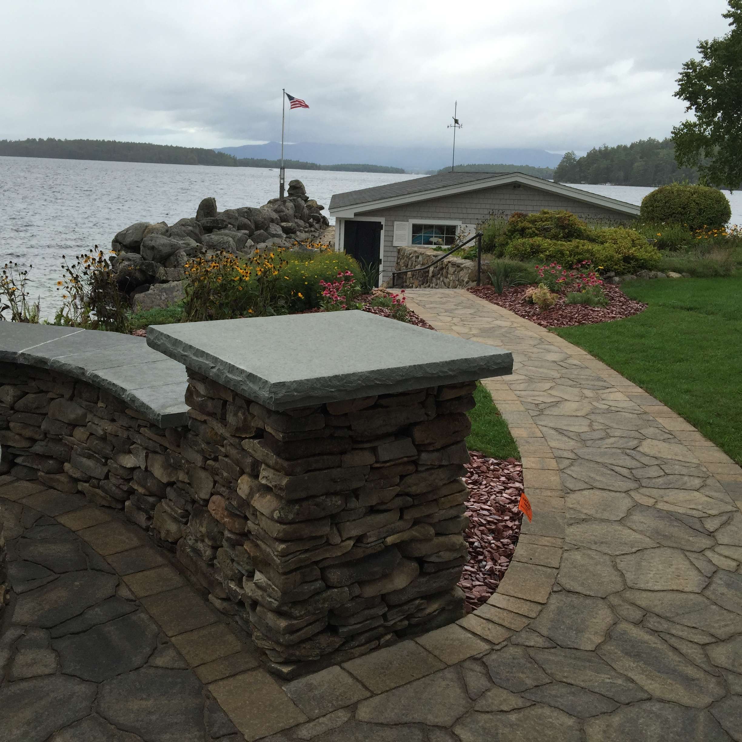 Guide to choosing landscaping materials featuring natural stone, pavers, granite, retaining wall options, mulch, and hardscape design inspiration for New Hampshire outdoor living projects by Landscapes by Tom