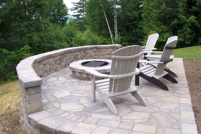 White Mountains outdoor fire pit patio featuring natural stone hardscaping, Adirondack seating area, granite accents, and professionally designed backyard landscaping for a cozy New Hampshire retreat